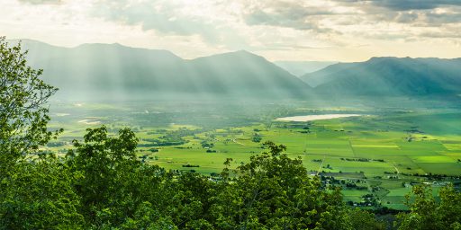 A green valley with mountains and bright clouds