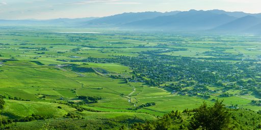 Green valley with a mountain range in the background