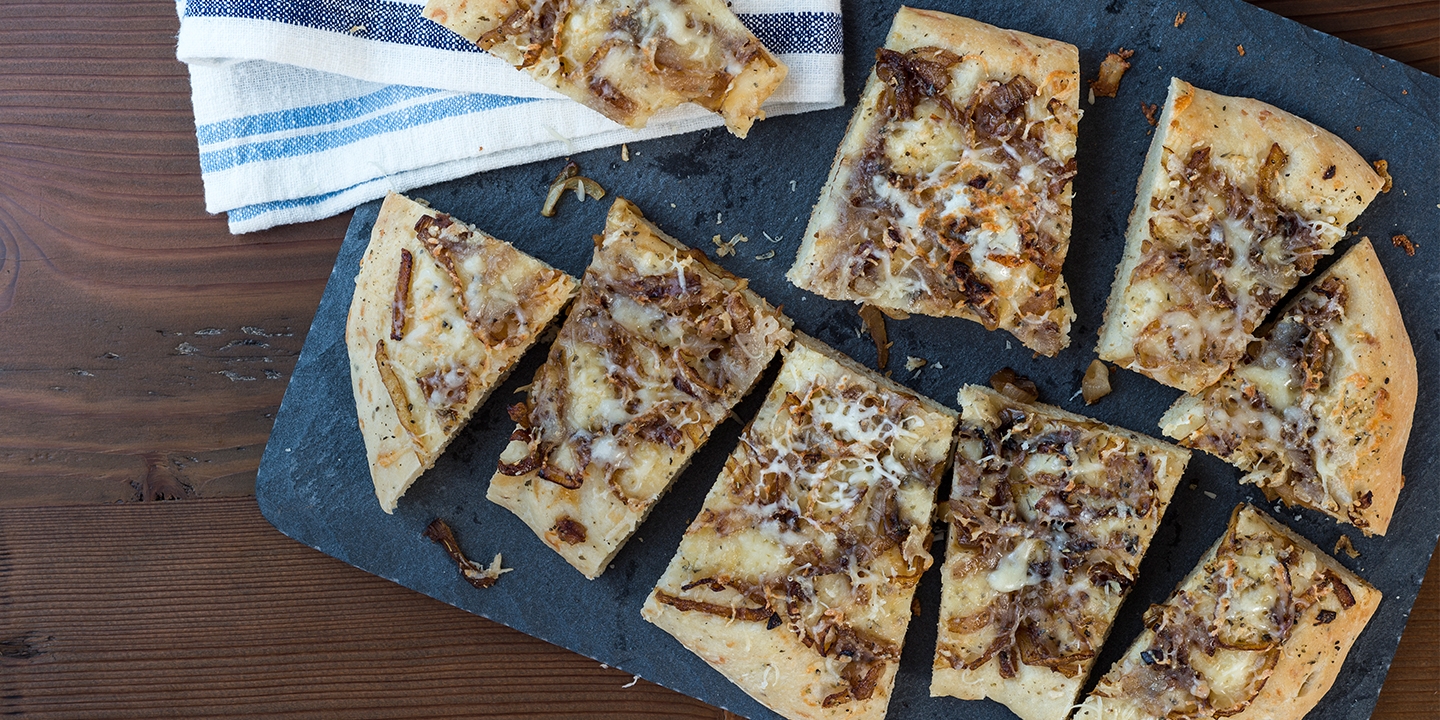 Focaccia Bread with Caramelized Onions served on a stone board