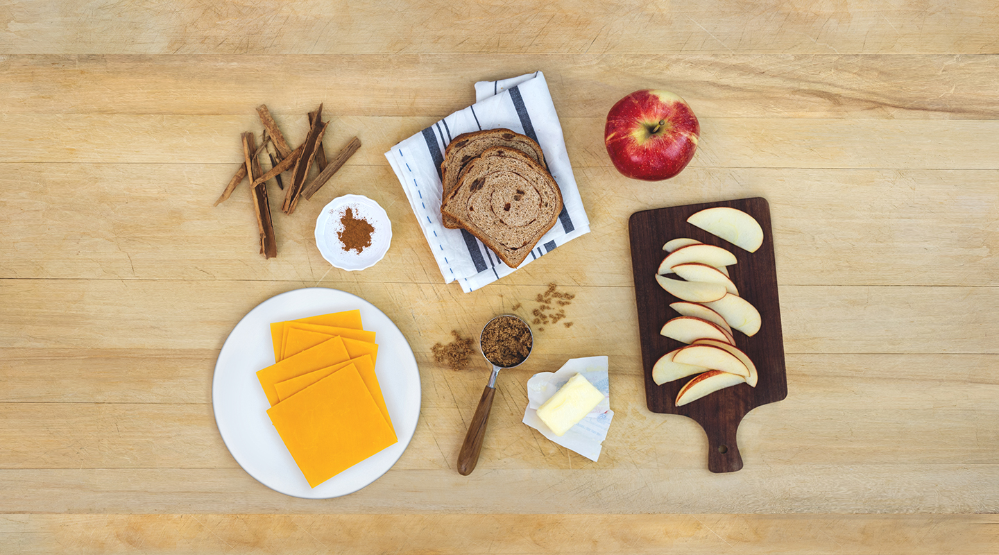 Ingredients for Apple Pie Grilled Cheese Sandwich on a wooden countertop