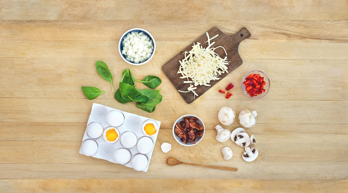 Ingredients for Farmhouse Bacon Swiss Frittata on a wooden countertop