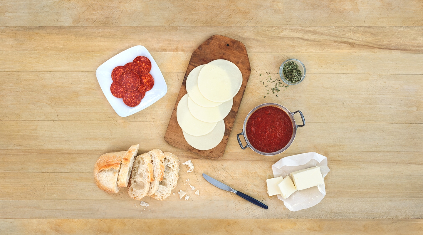 Ingredients for Pizza Grilled Cheese Sandwich on a wooden countertop