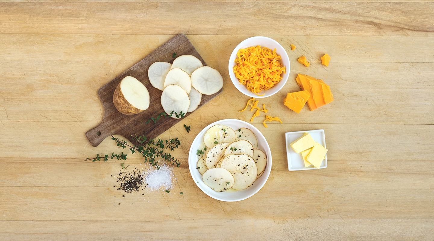 Ingredients for Cheesy Potato Bake on a wooden countertop