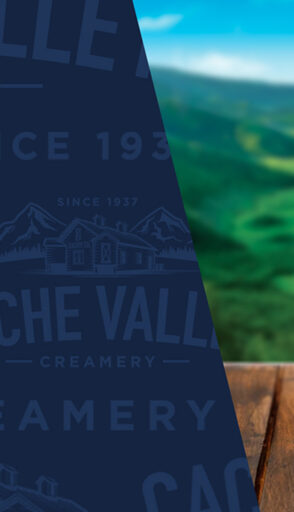 Cache Valley blue pattern overlaying a wooden table and green valley with blue sky