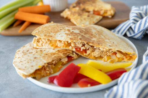 Quesadillas on a plate with veggie garnish and buffalo ranch dip